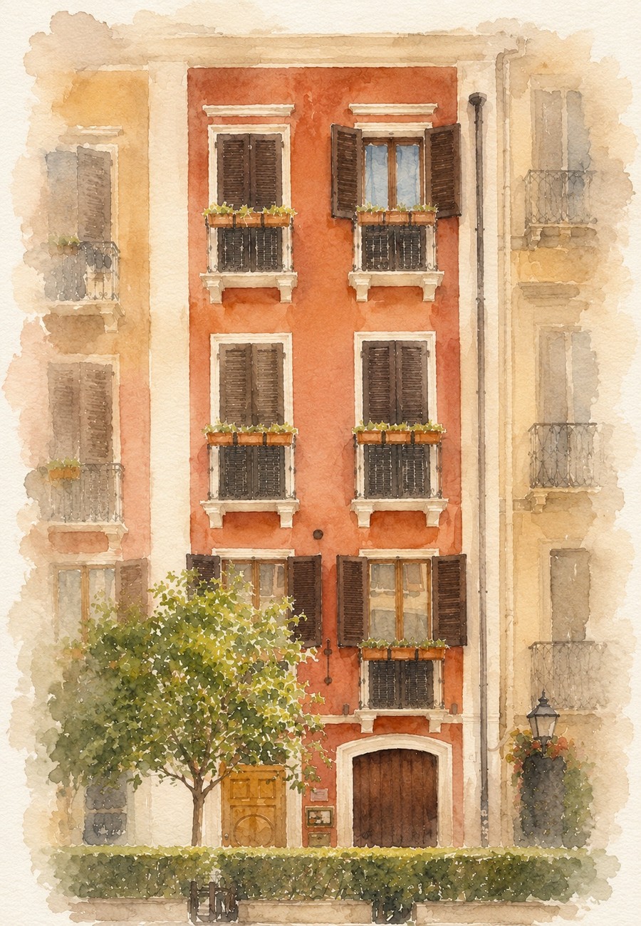 The facade of Le Suite sul Corso in Cagliari: red townhouse with arched door and orange tree in front