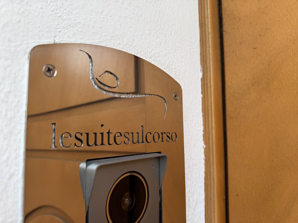 The Le Suite sul Corso intercom with the logo engraved on a metal plate