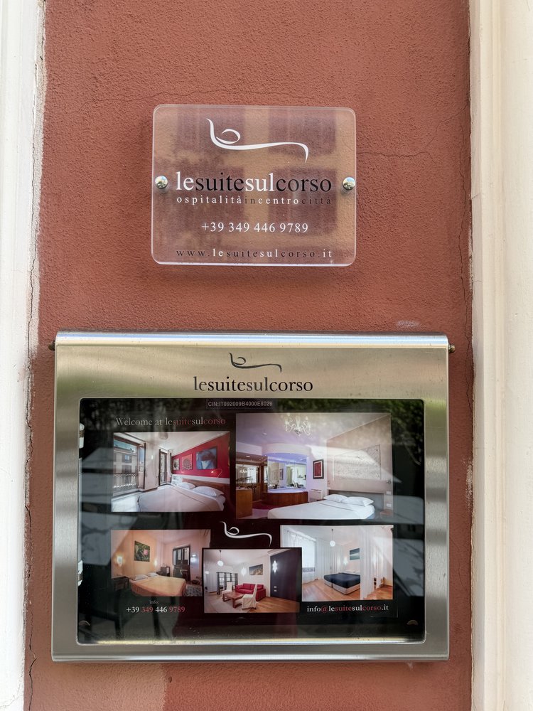 The Le Suite sul Corso sign next to the door, with information window