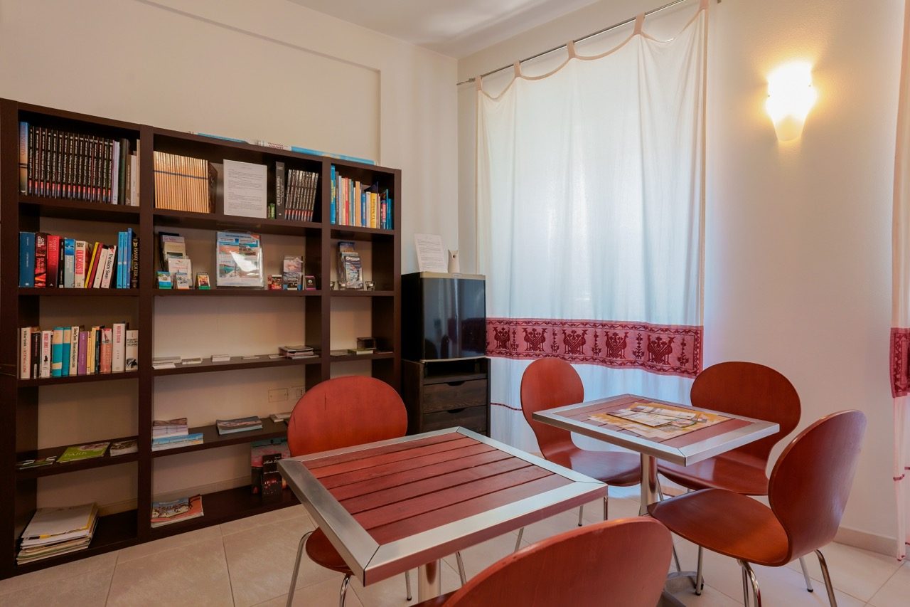 The Saletta common room at Le Suite sul Corso: library with books about Sardinia